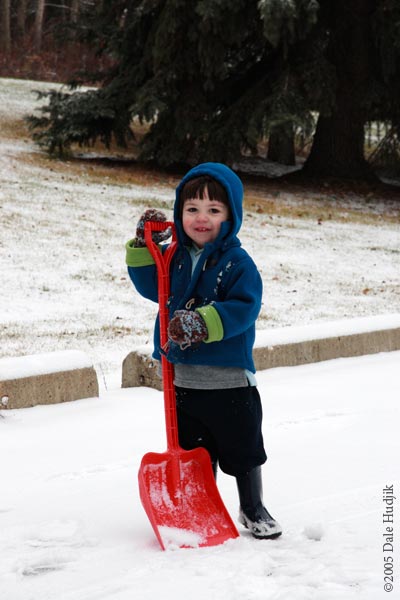 Two year old boy shovelling snow