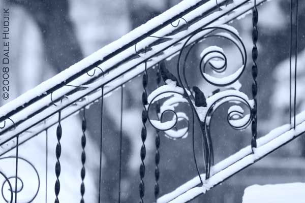 snow on iron railing